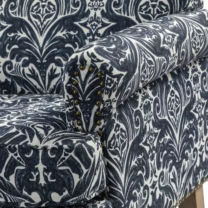 Fauteuil rembourré en bois avec motif floral, accoudoirs à panneaux et dossier en forme de bosse de chameau.