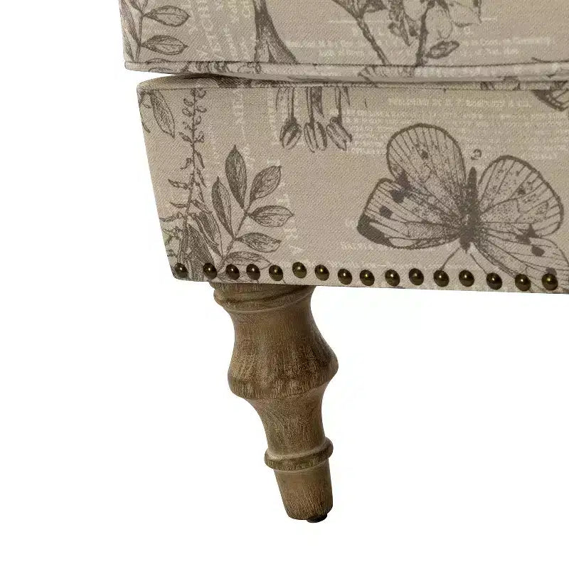 Fauteuil rembourré en bois avec motif floral, accoudoirs à panneaux et dossier en forme de bosse de chameau.